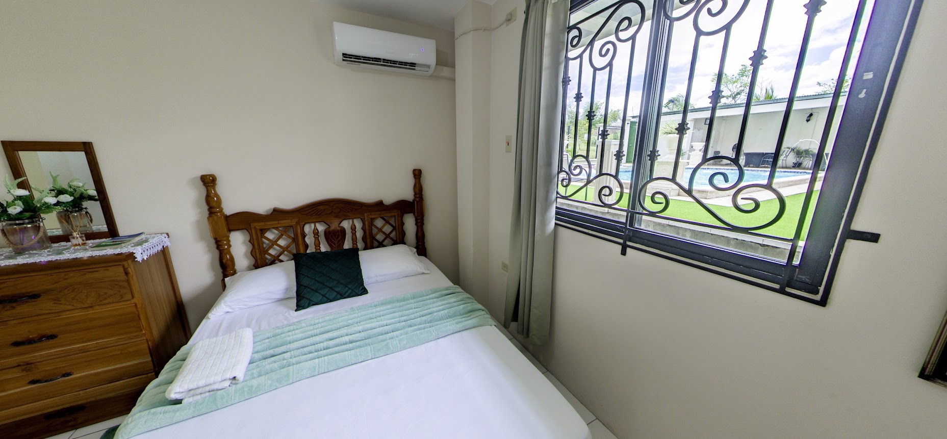 Garden suite bedroom with poolside window view