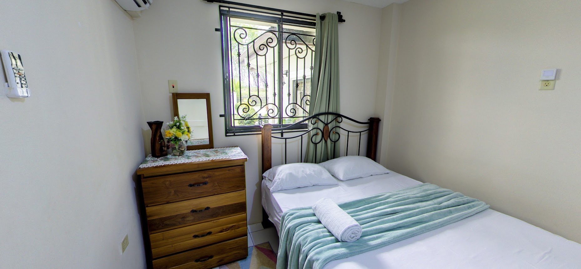 Bedroom with wooden dresser and garden window
