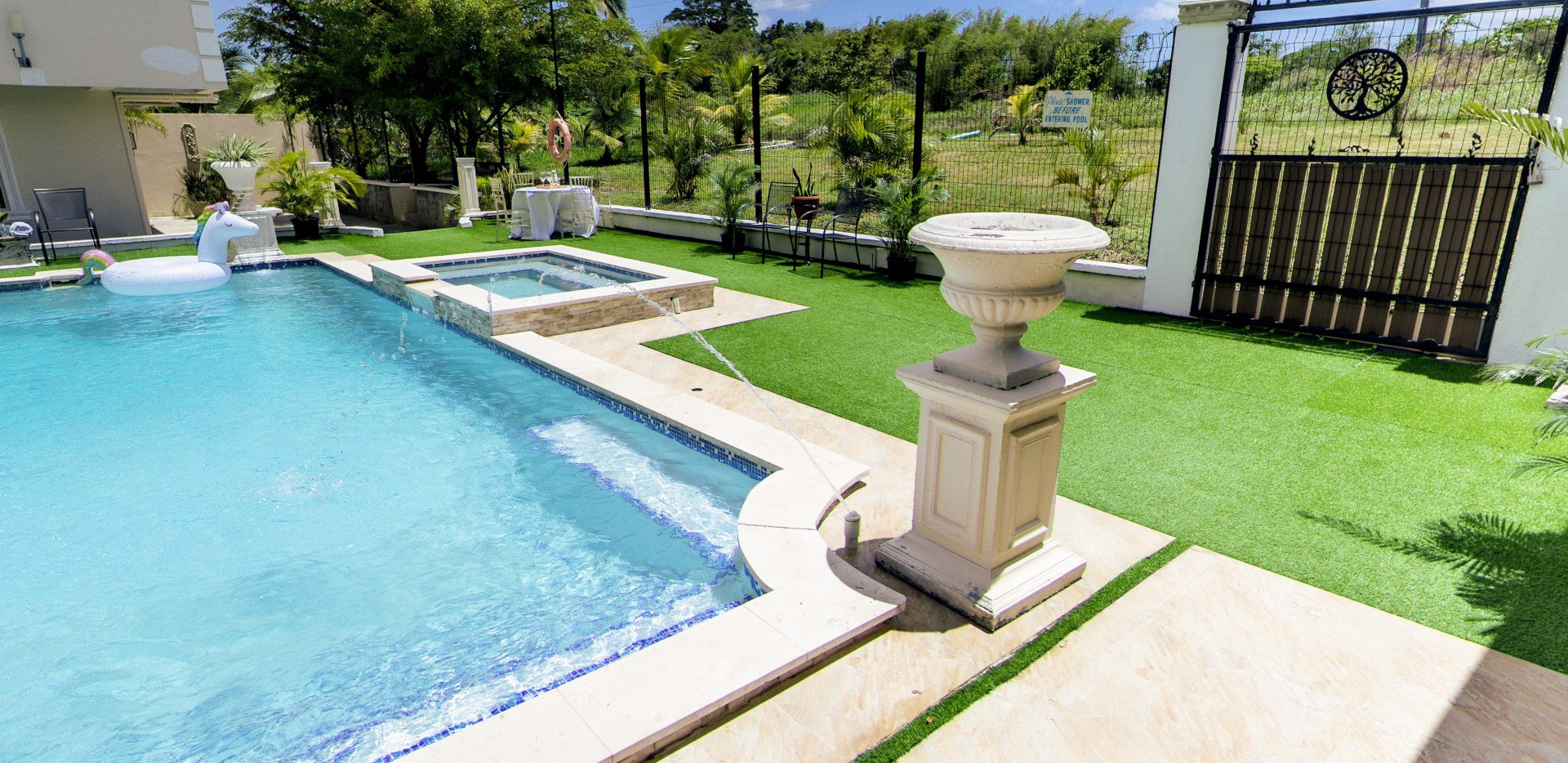 Pool with unicorn floatie, jacuzzi and fountain urn