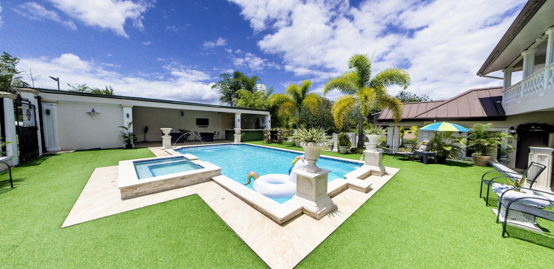 Corner view of pool, jacuzzi and cabana bar